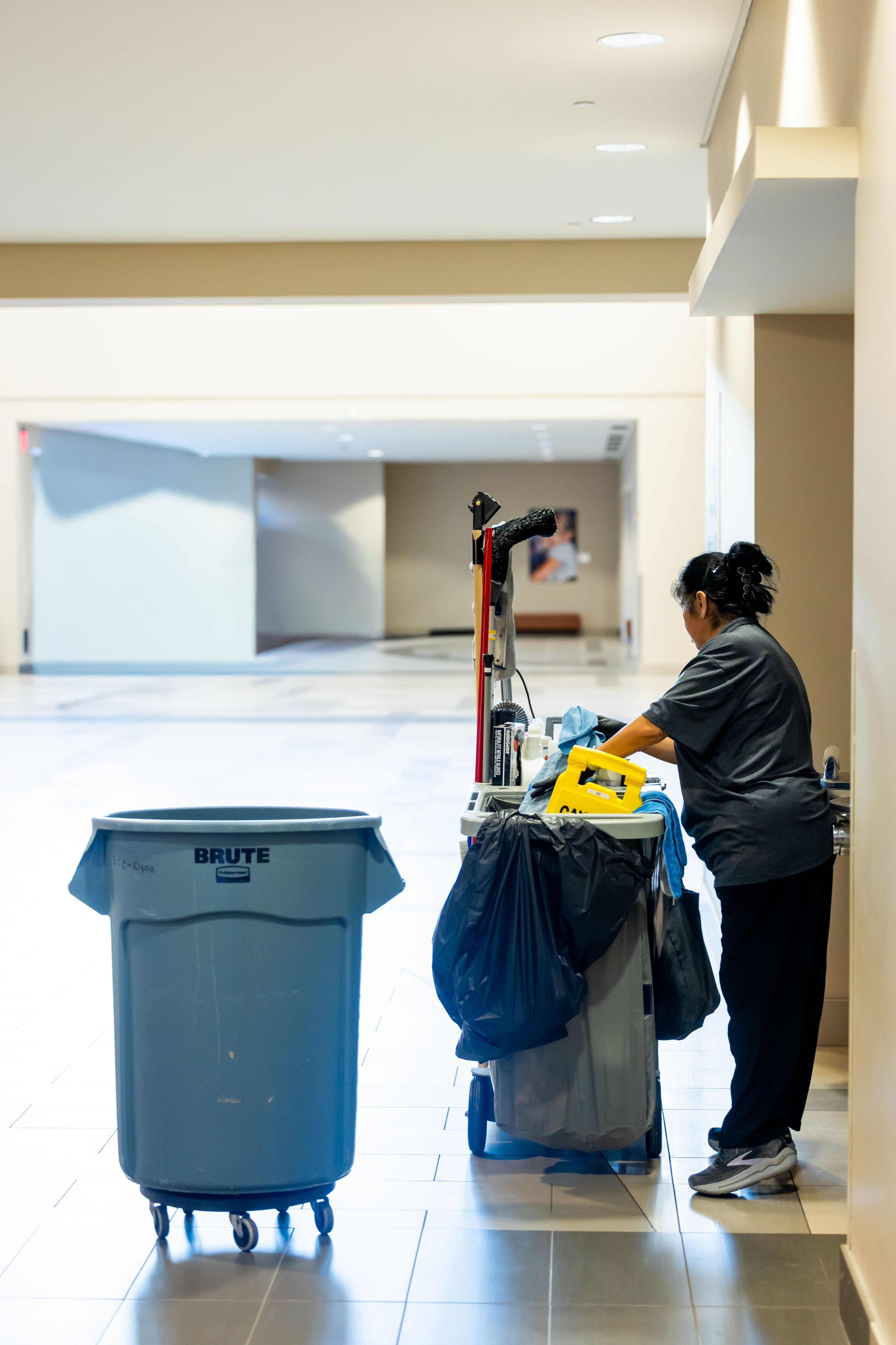 A professional cleaner working with a cleaning trolley