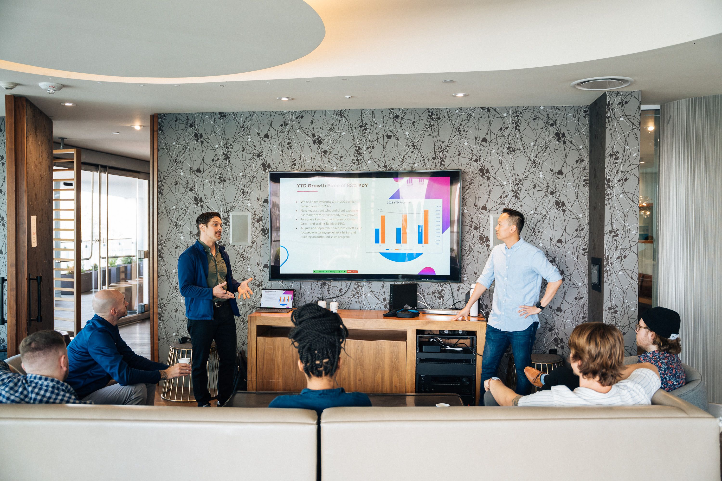 Business colleagues discussing charts on a presentation screen